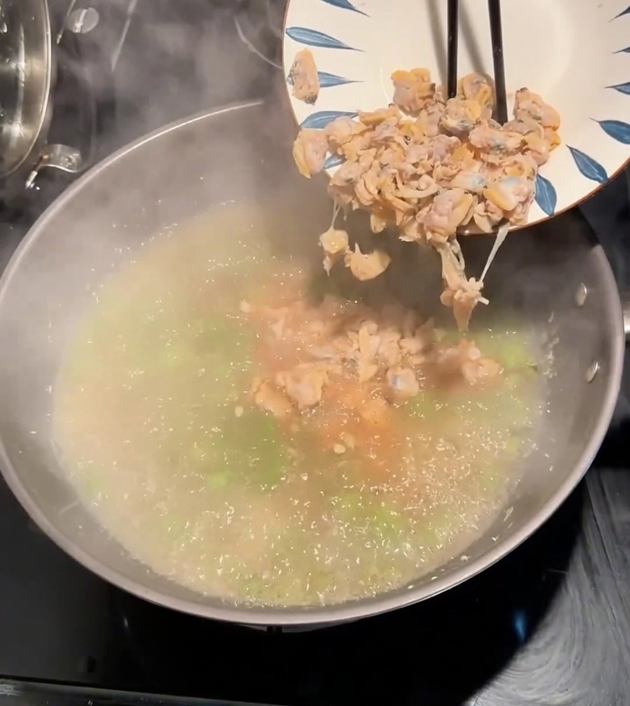 Chair de palourde ajoutée dans le bouillon bouillonnant avec les légumes verts.