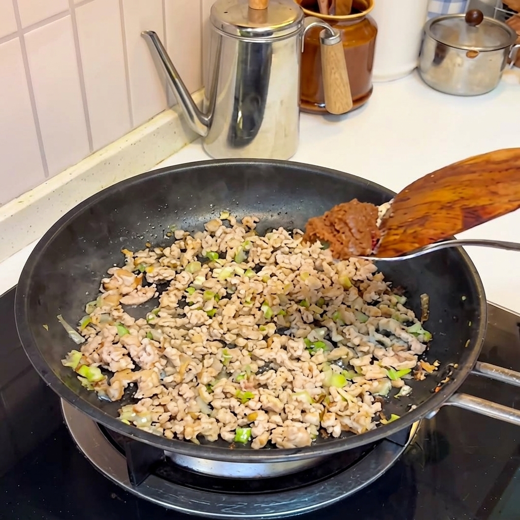 Pâte miso ajoutée au porc cuit dans la poêle.
