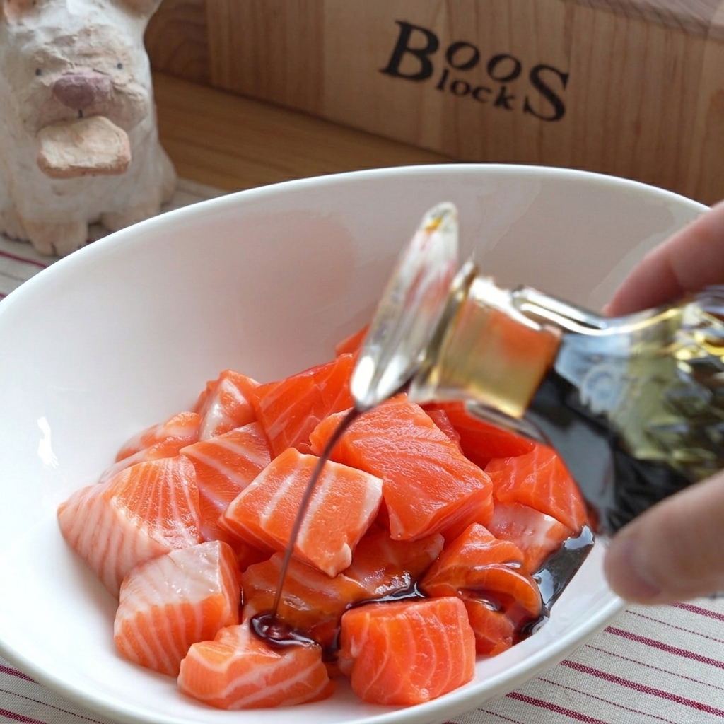 Un bol de dés de saumon cru frais avec diverses sauces versées par-dessus.