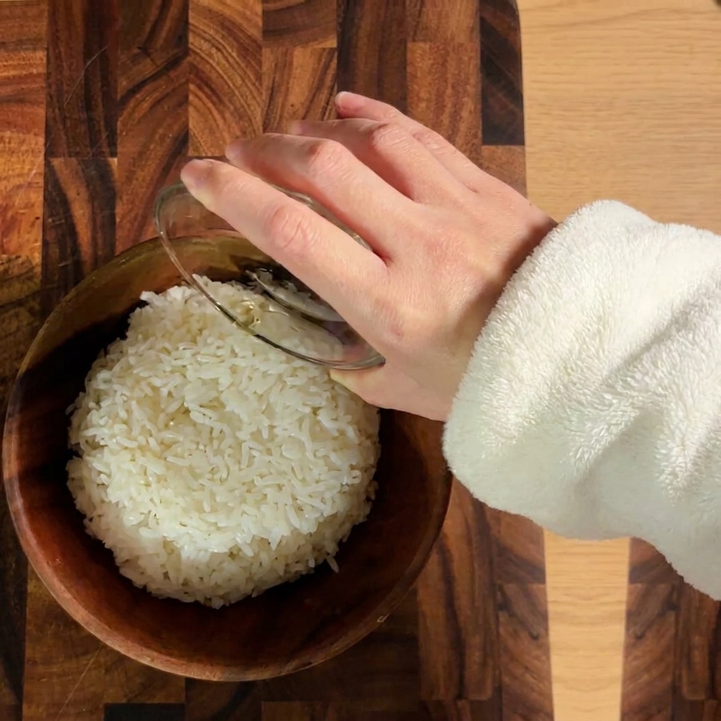 Riz blanc cuit assaisonné avec du vinaigre à sushis dans un bol en bois.