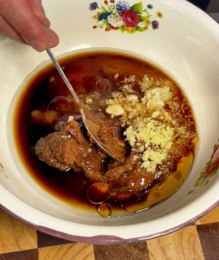 La marinade au Doenjang est mélangée à laide dune cuillère jusquà obtenir une texture lisse et homogène.