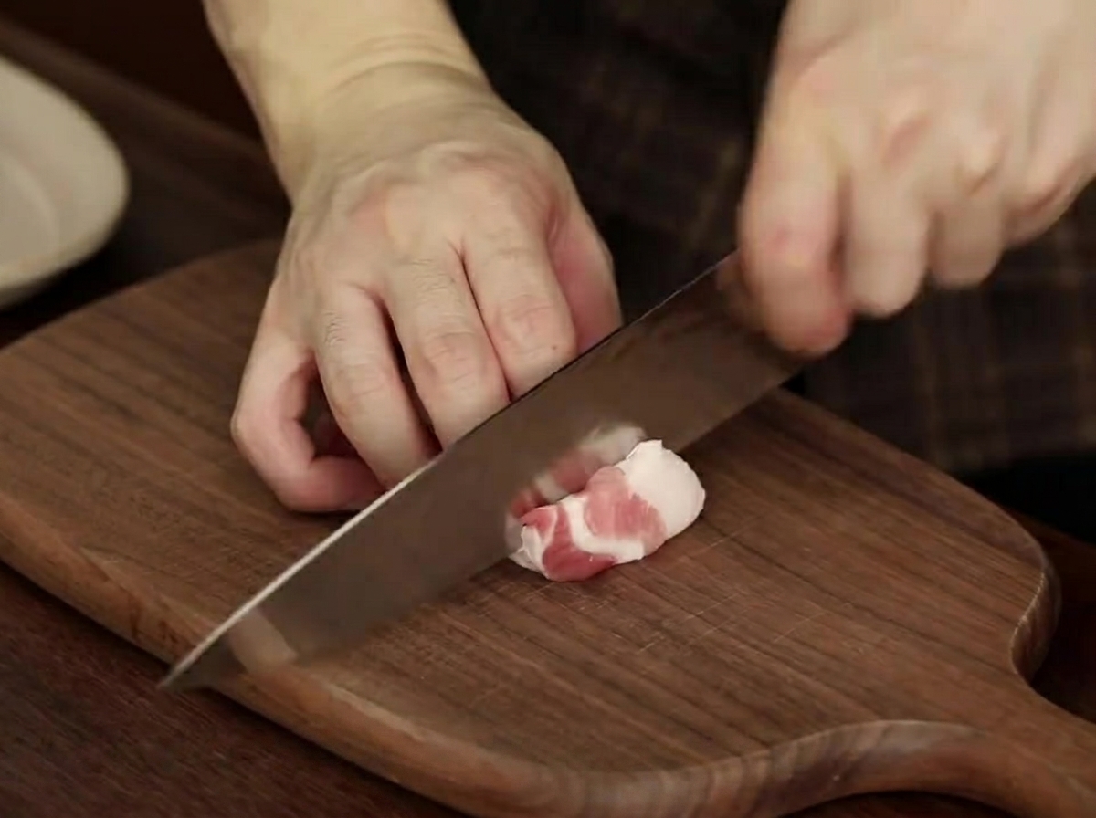 Tranches de poitrine de porc crue disposées proprement sur une assiette, prêtes pour le ragoût.
