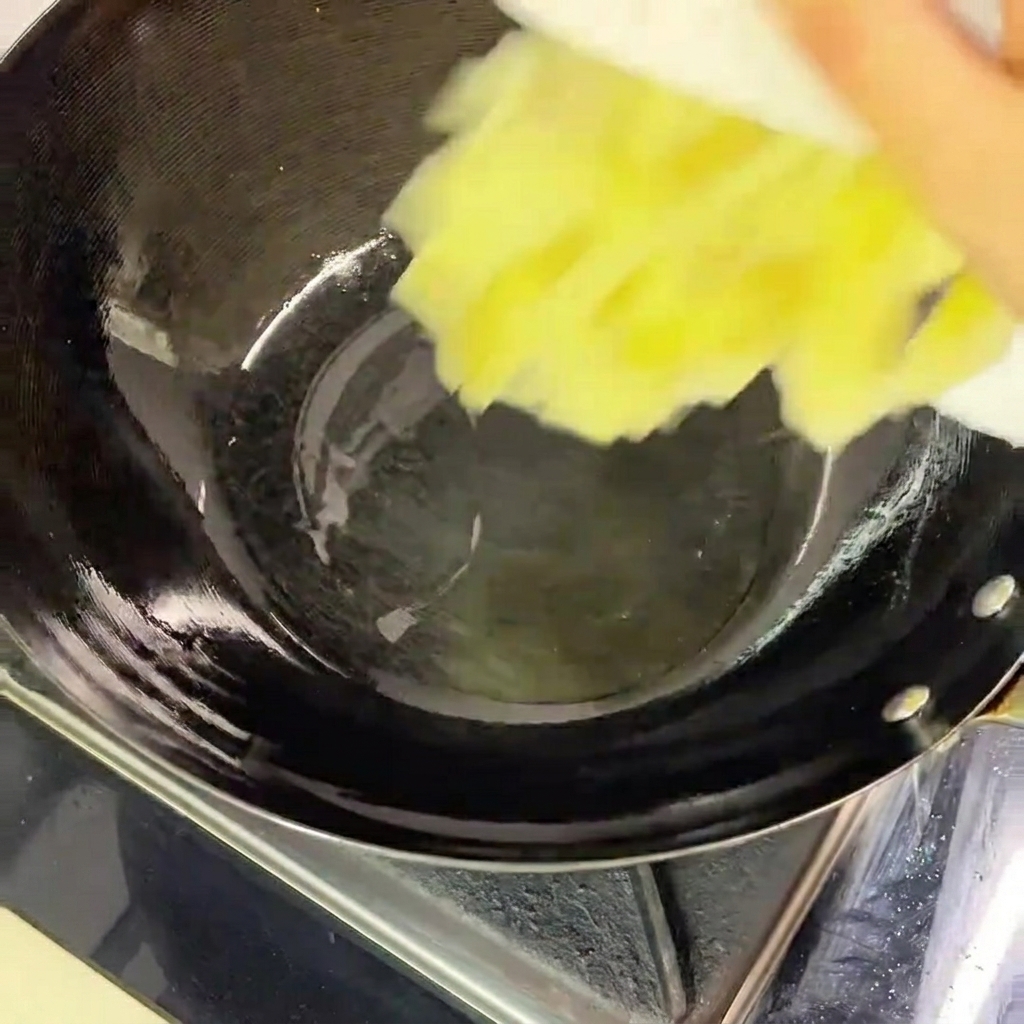 Chou mariné haché versé dune assiette blanche dans un wok noir chaud contenant un fond dhuile.