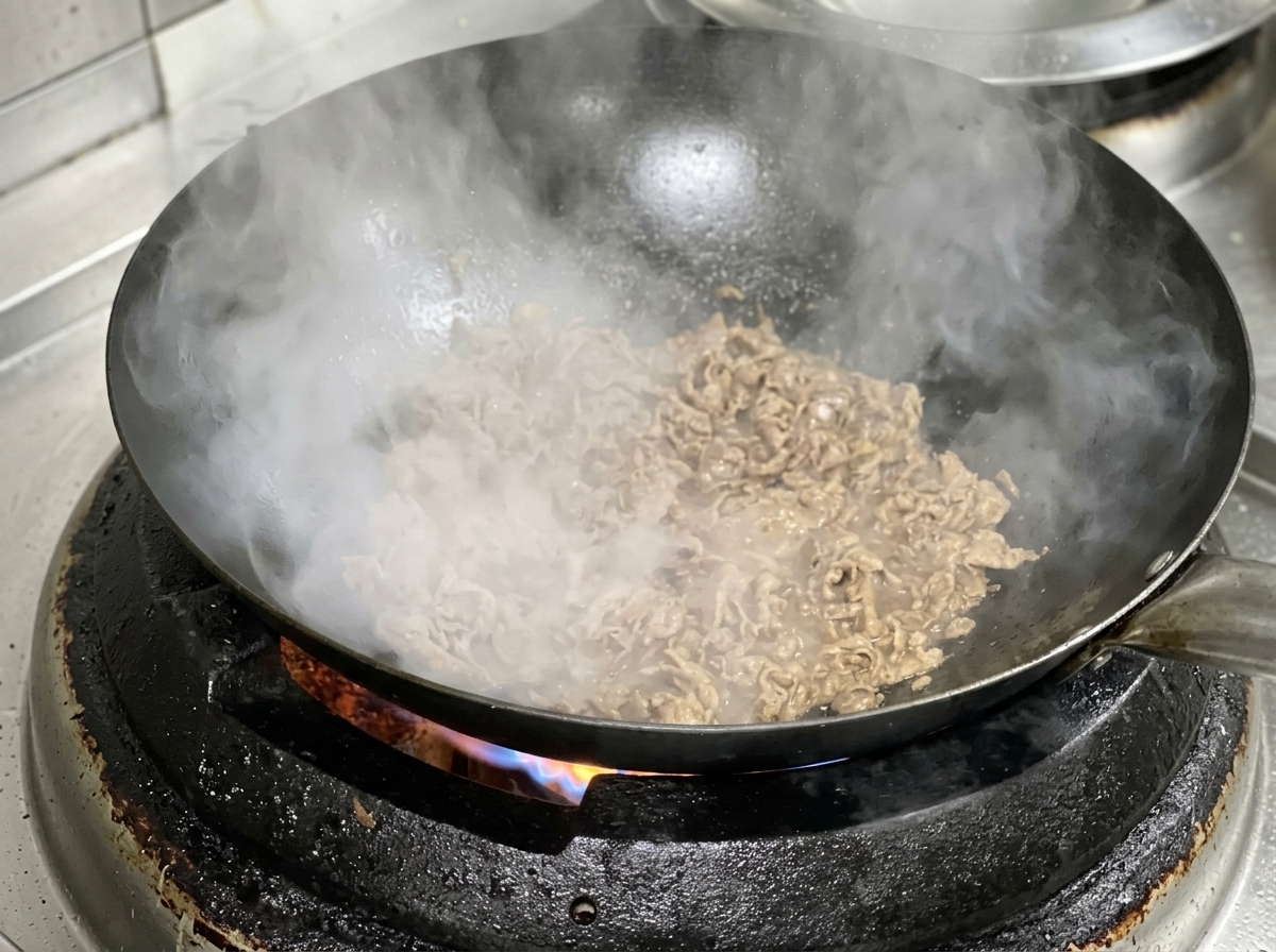 Tranches de bœuf et doignon cuisant ensemble dans un wok chaud.