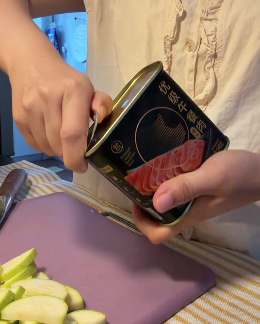 Un bloc de viande en conserve retiré de sa boîte métallique ouverte.