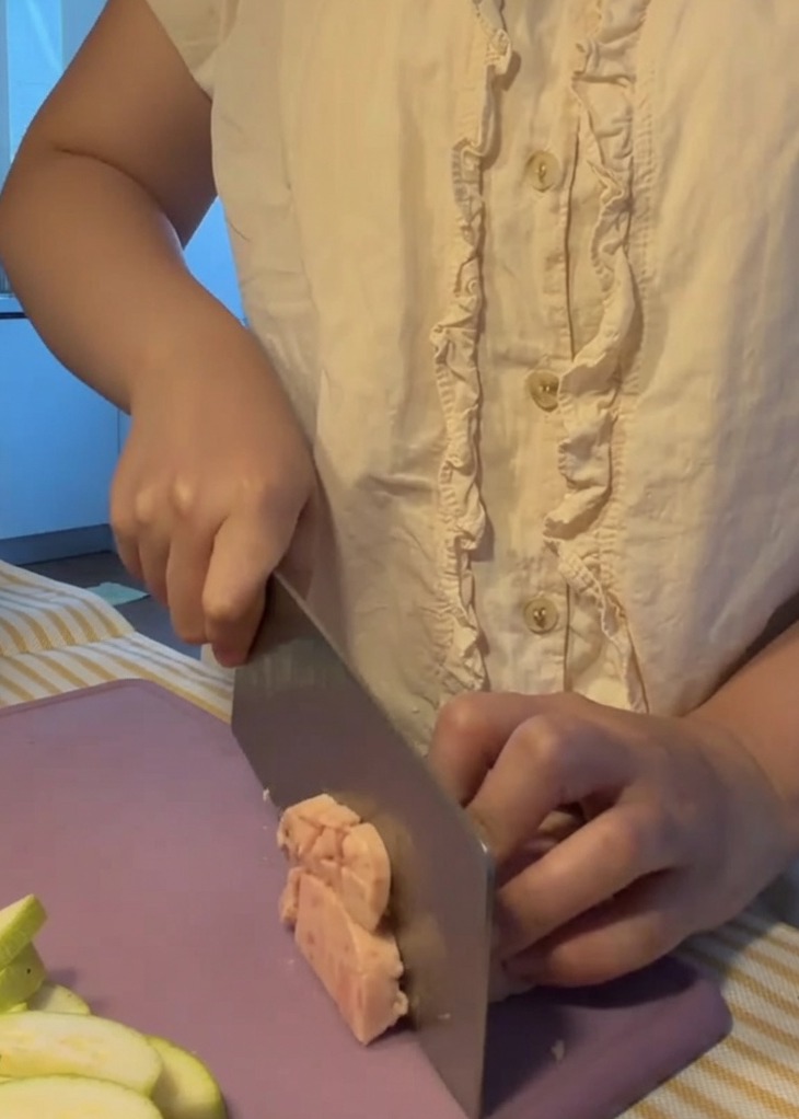 Viande en conserve coupée en petits cubes réguliers sur une planche à découper violette.