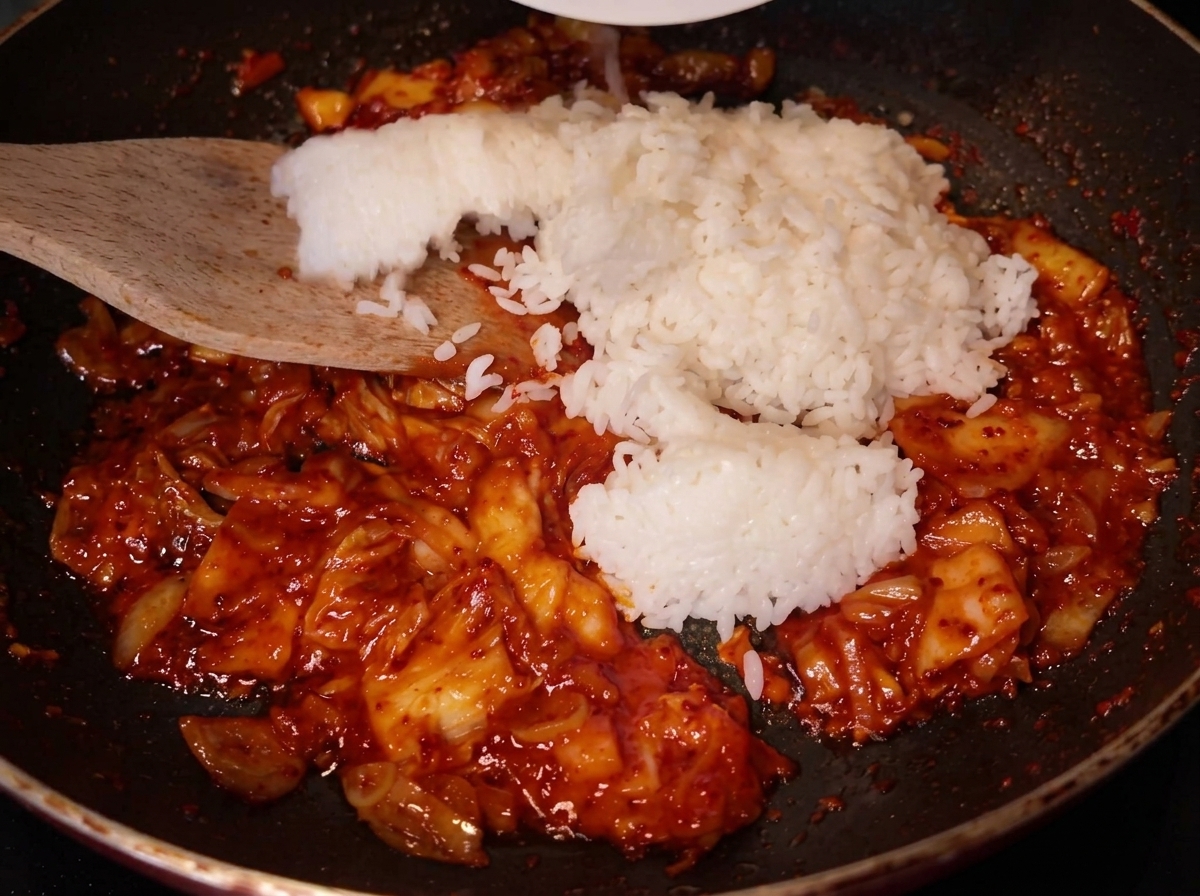 Ajout du riz blanc dans la poêle contenant le kimchi sauté.