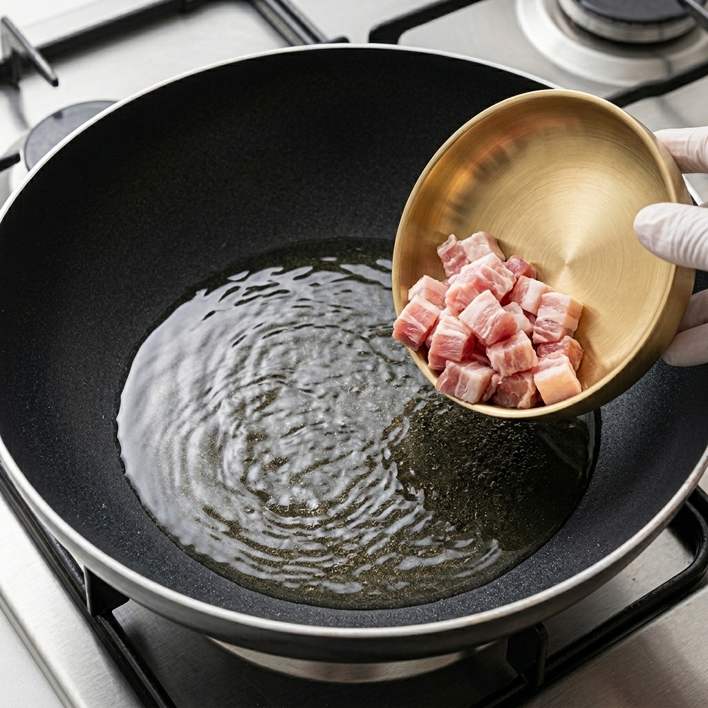 Fines tranches de poitrine de porc qui dorent dans une poêle chaude.