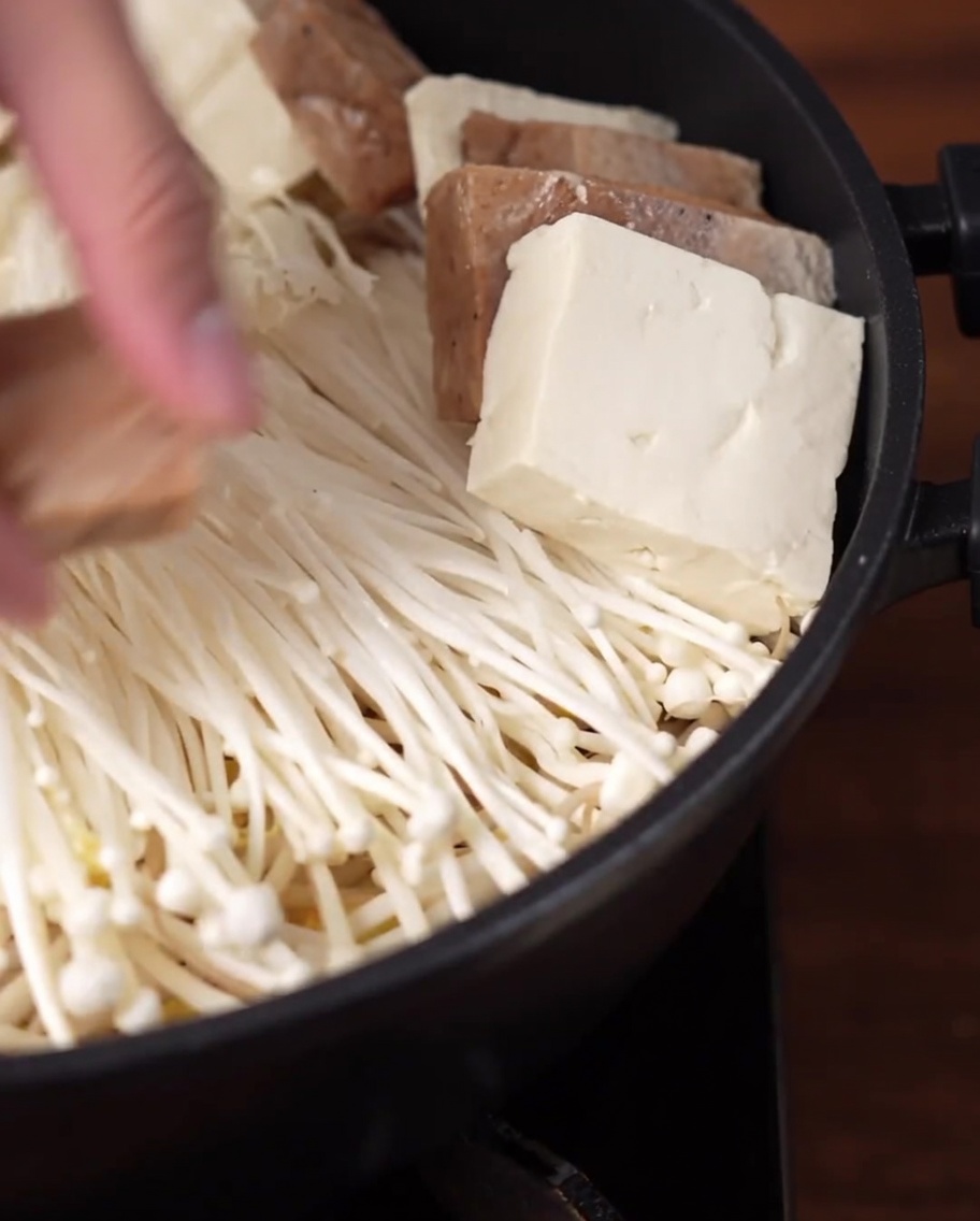 Tranches de tofu et de substitut de viande disposées en cercle dans la marmite.