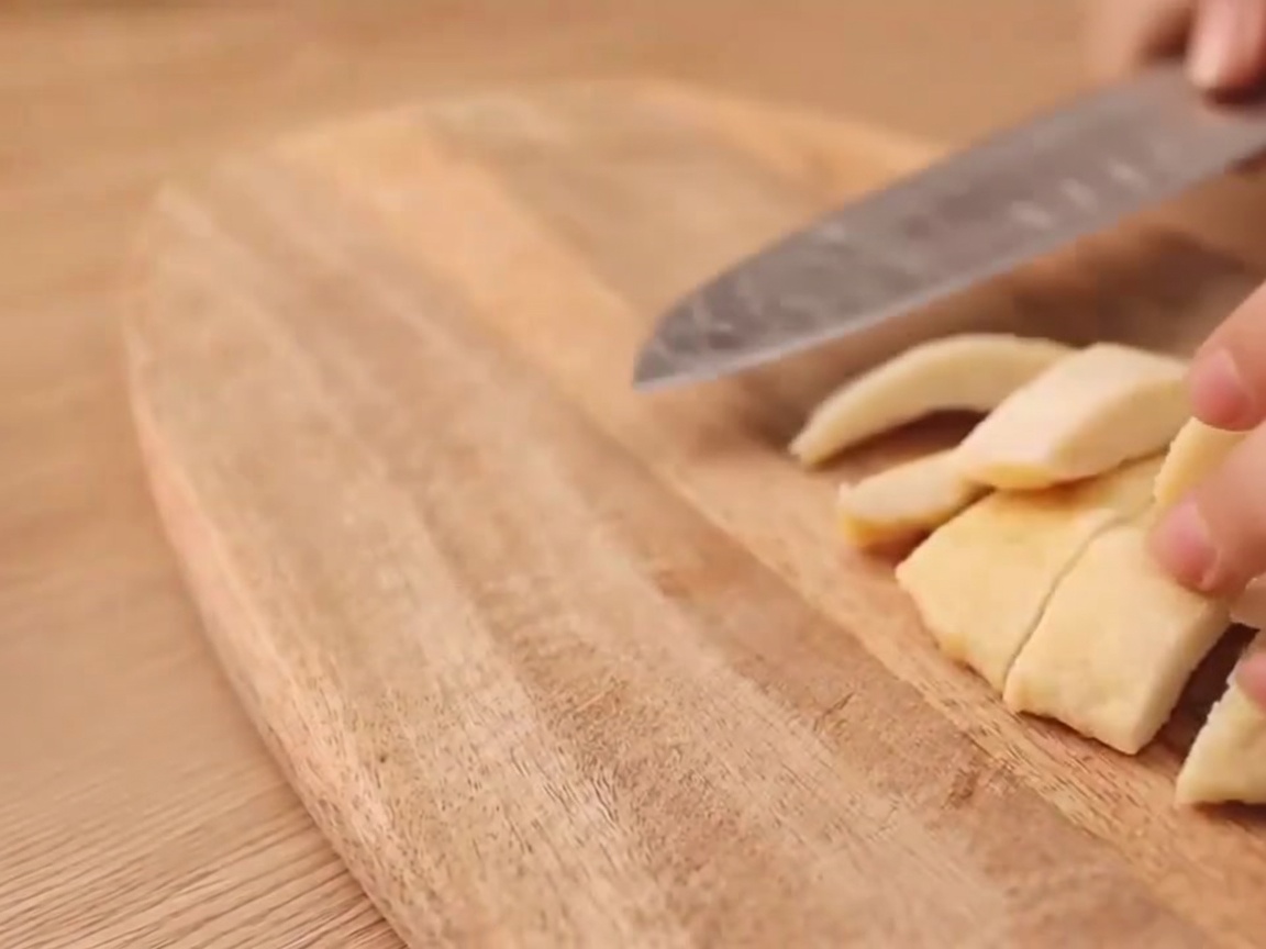 Gros plan dun couteau faisant une entaille en forme de I sur une saucisse végétarienne.