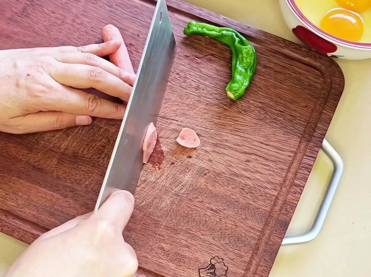 Rondelles de saucisse disposées sur une planche à découper en bois.