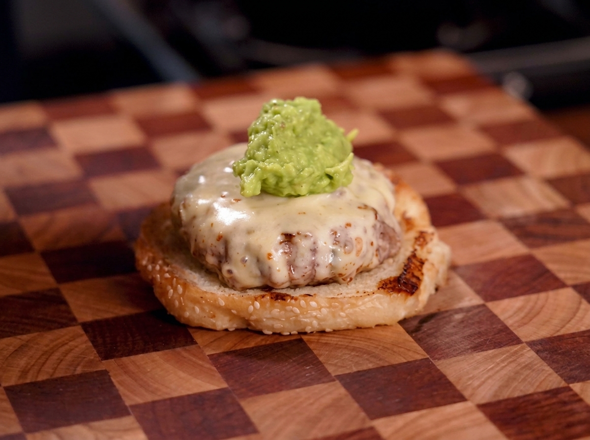 Une cuillerée de guacamole vert sur le steak au fromage.