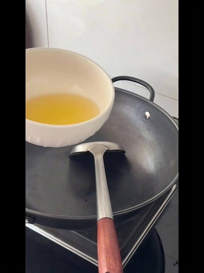Huile de cuisson versée dans un grand wok vide.