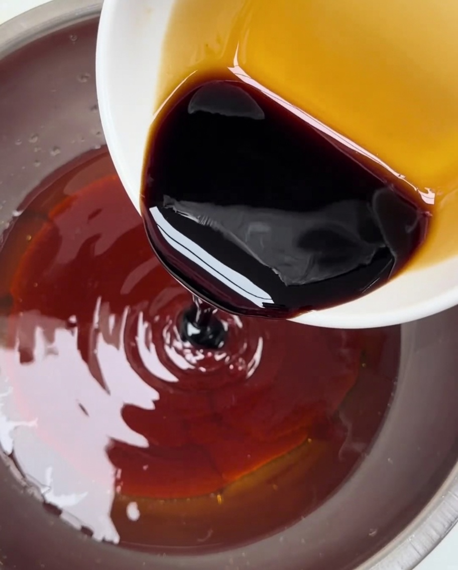 La sauce soja versée dun petit bol dans un récipient plus grand contenant le mélange de pâte de piment.