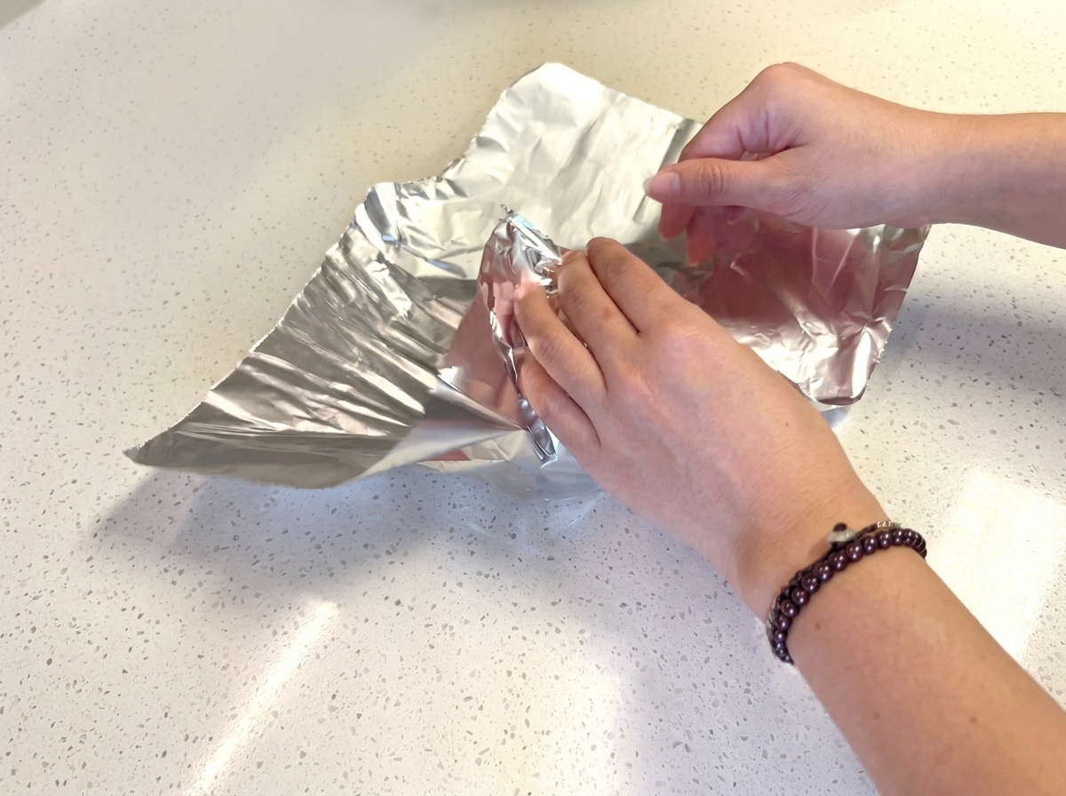 Pains à burger enveloppés individuellement dans des carrés de papier daluminium.