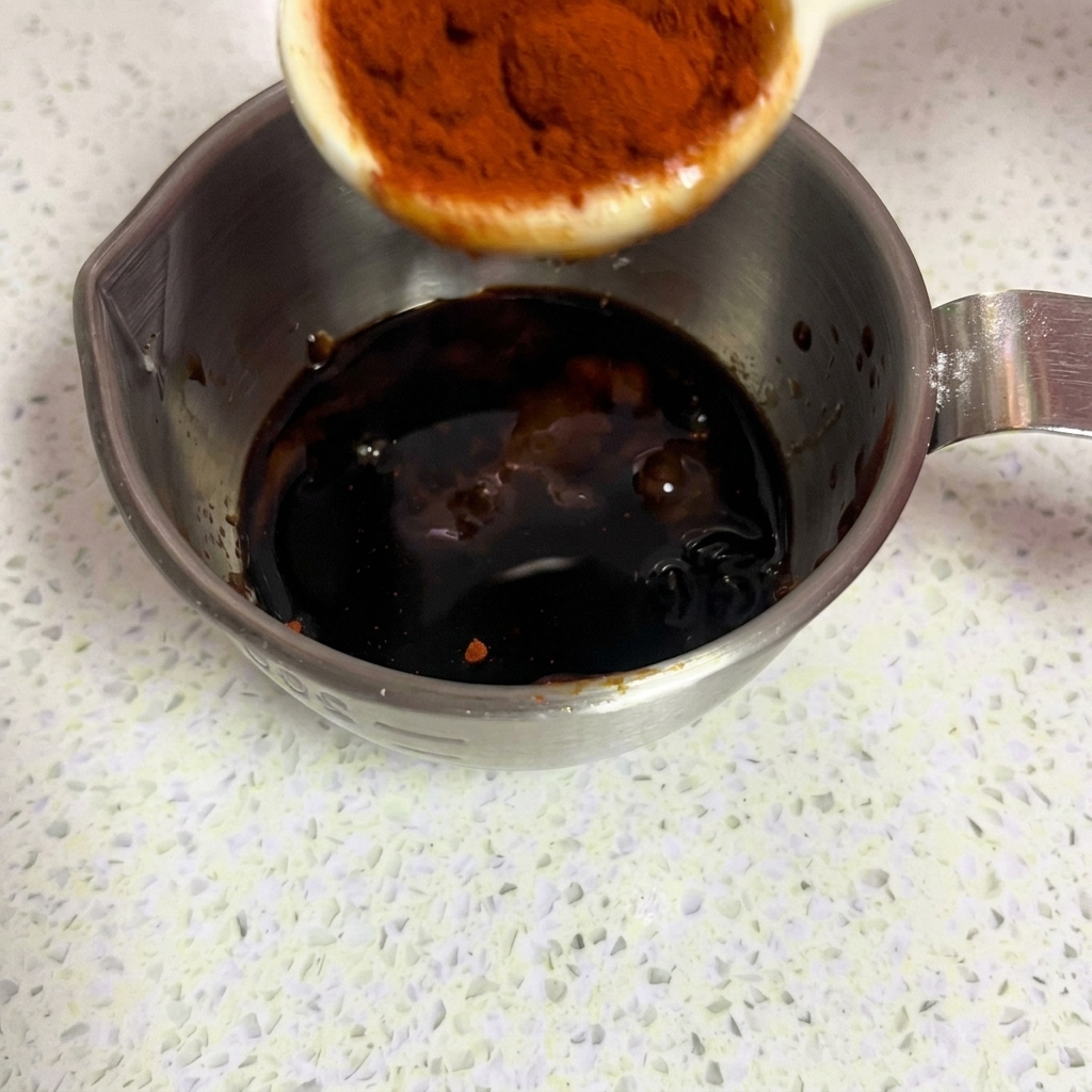 De la poudre de paprika doux dun rouge vif saupoudrée dans la marinade.