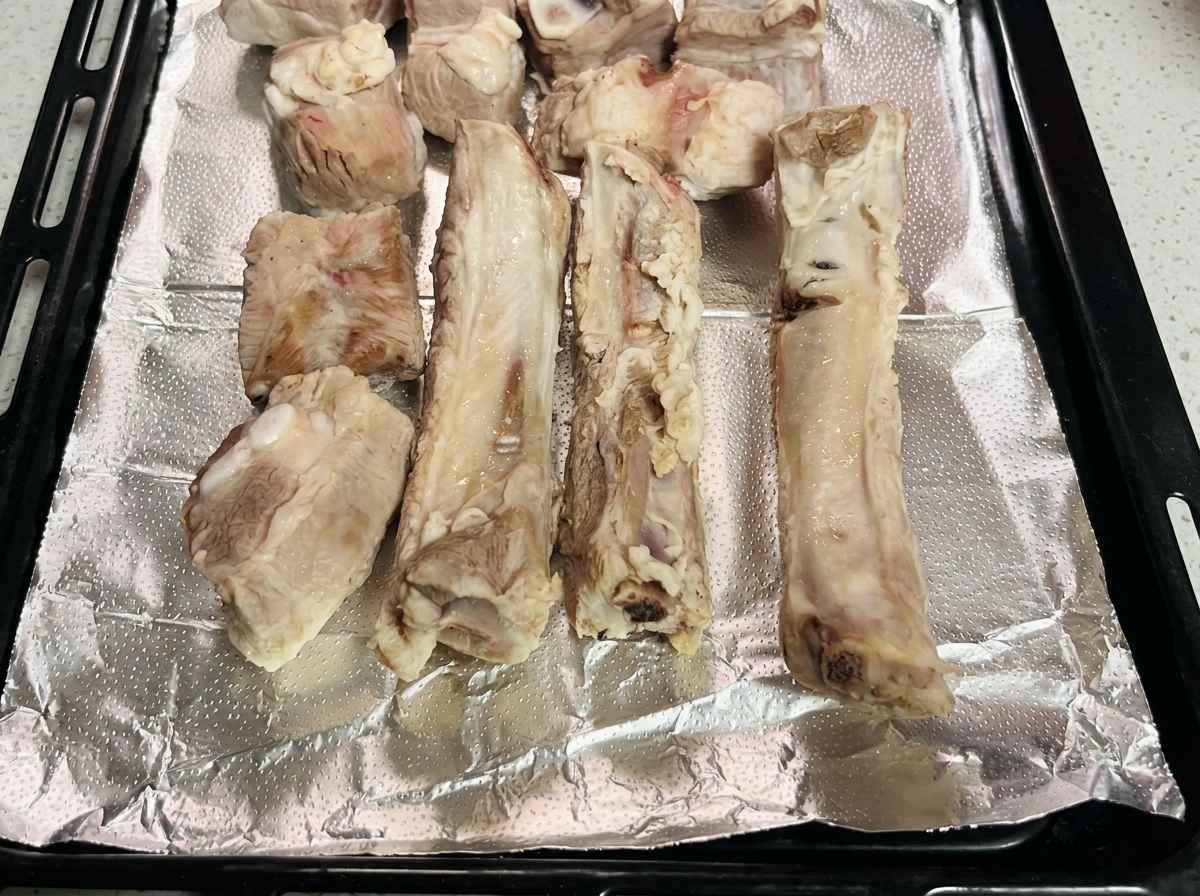 Les morceaux de porc blanchis disposés proprement sur une plaque recouverte de papier daluminium.