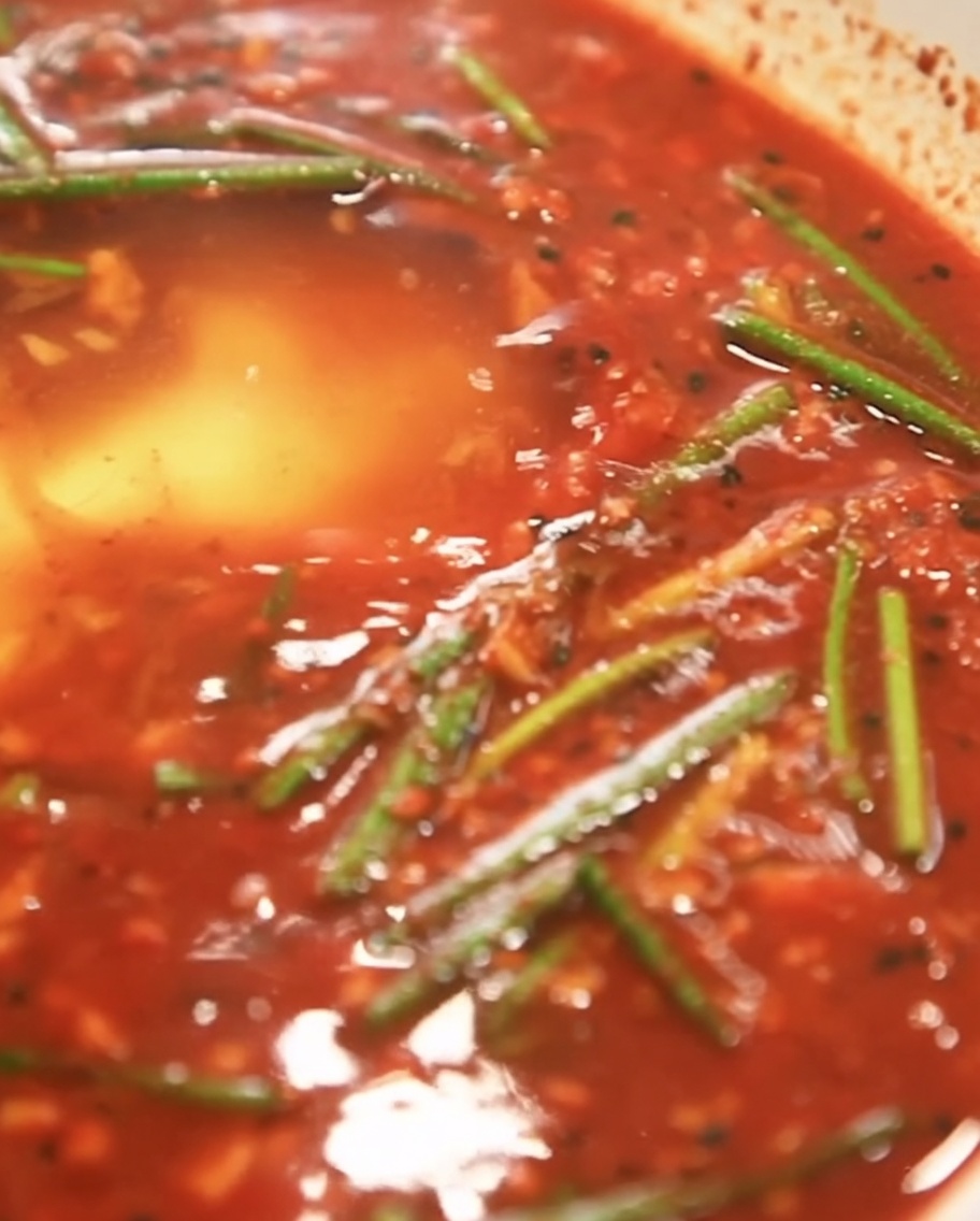 De la fécule blanche saupoudrée dans la base de marinade rouge.