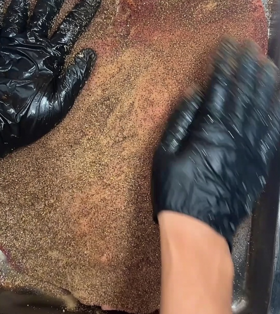 La poitrine crue assaisonnée reposant sur une grille à lintérieur dun réfrigérateur pour une marinade dune nuit.