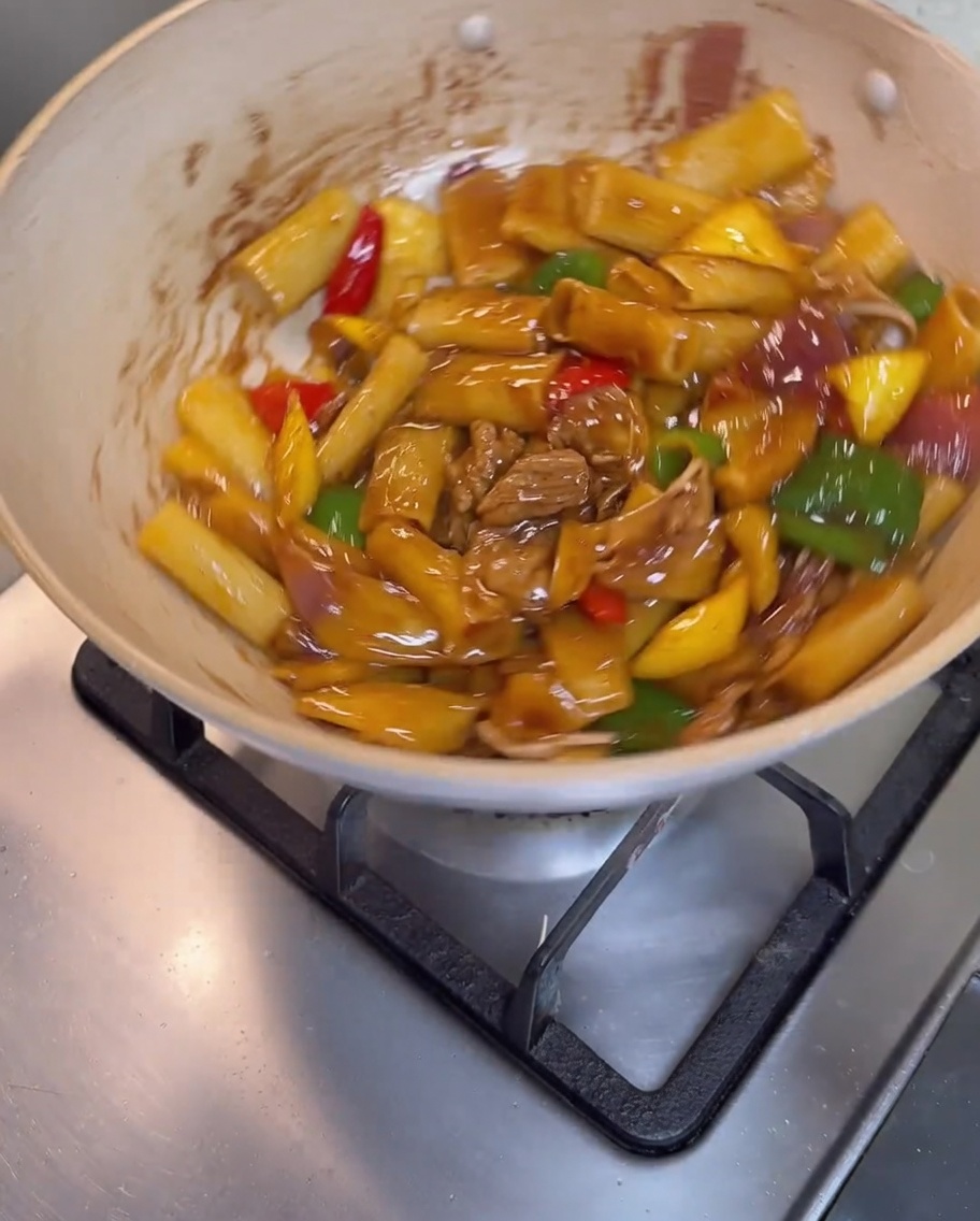 Rigatoni, viande et légumes mélangés dans la poêle jusquà être entièrement enrobés dune sauce brune brillante.