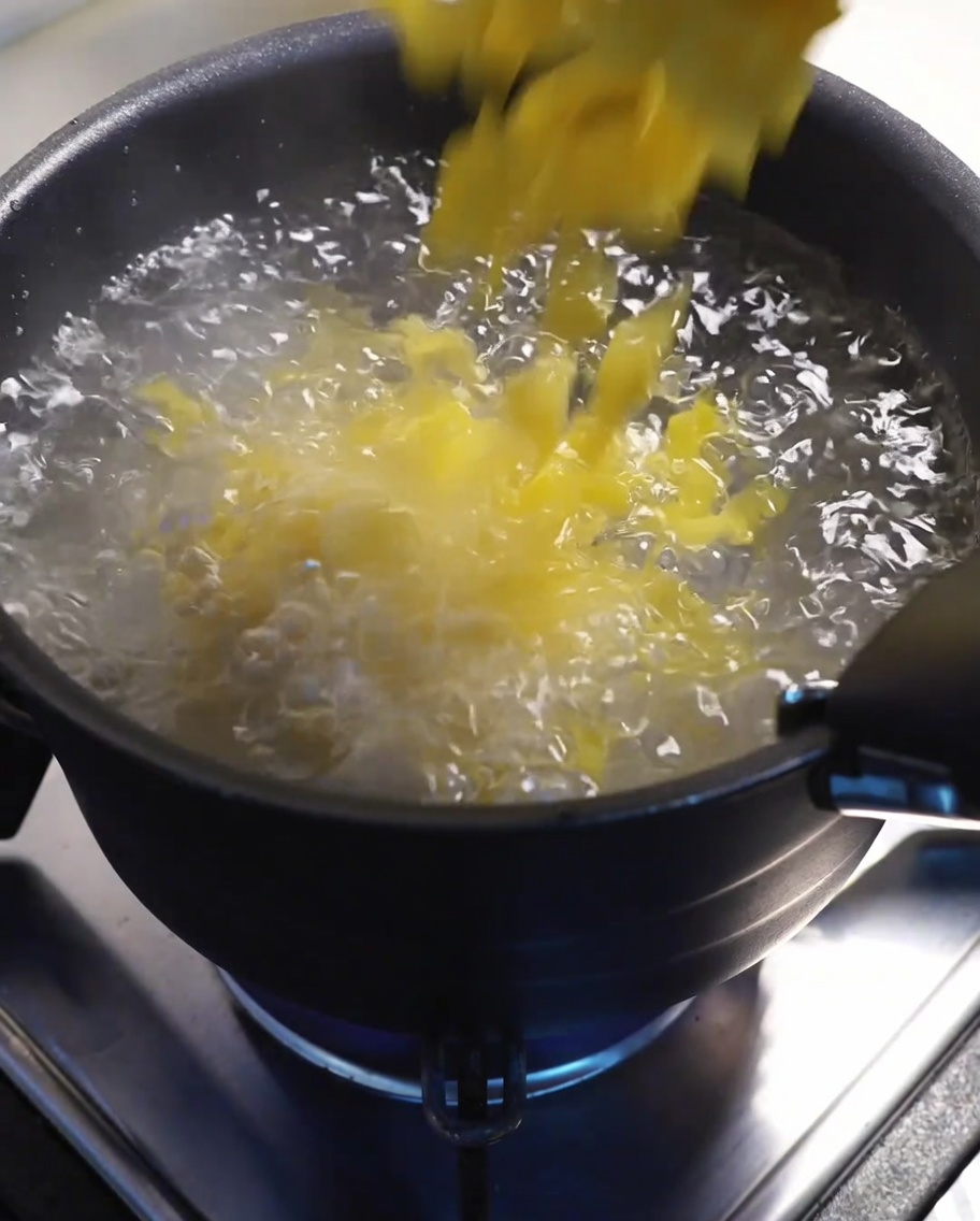 Macaronis en train de bouillir dans une grande casserole deau sur la cuisinière.