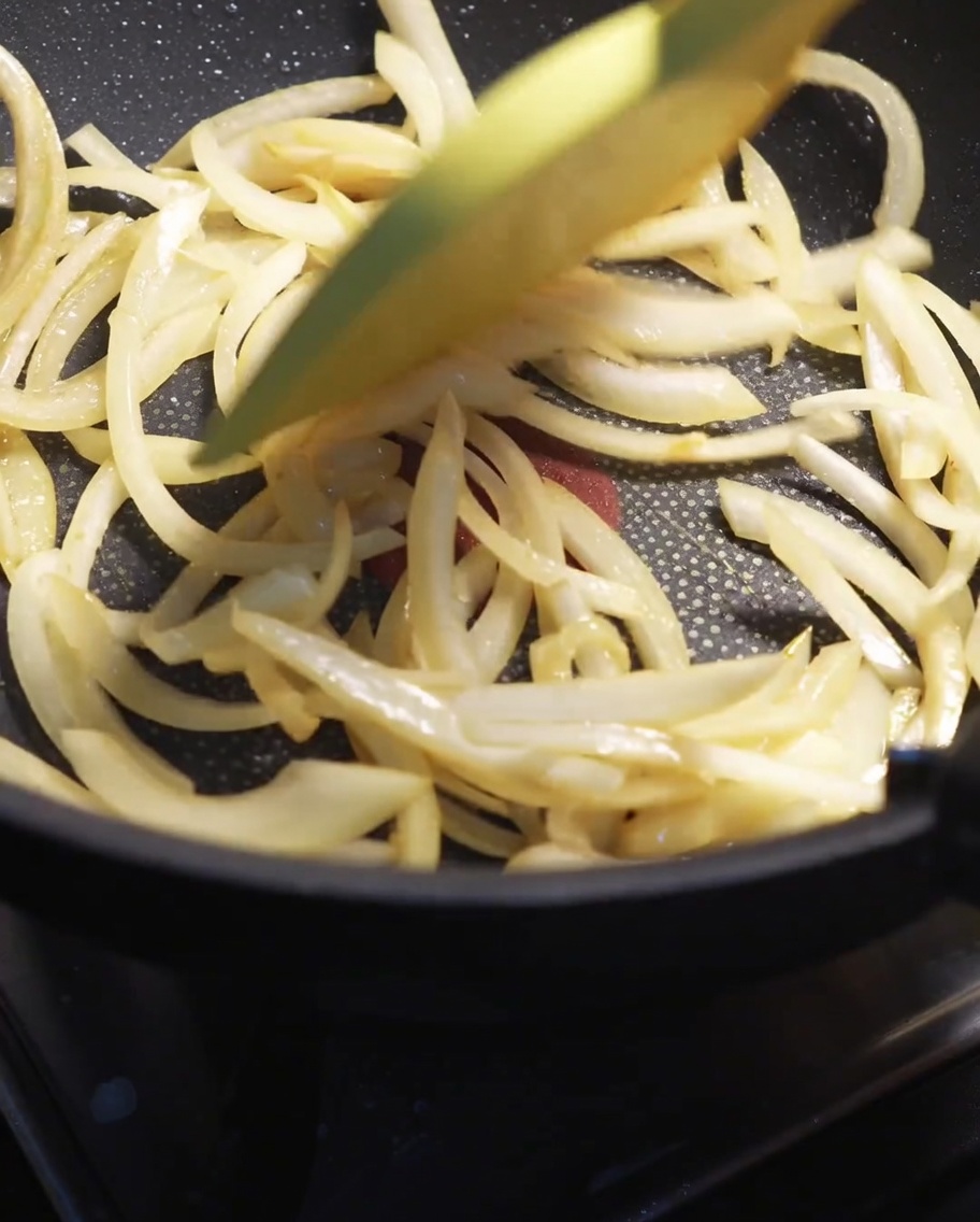 Tranches doignon blanc sautées à la spatule dans une poêle chaude jusquà ce quelles ramollissent.