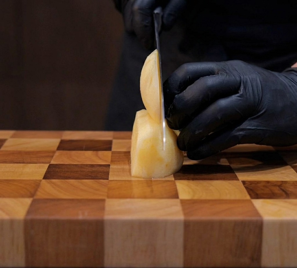 Pommes de terre coupées soigneusement en cubes dun centimètre sur une planche en bois.