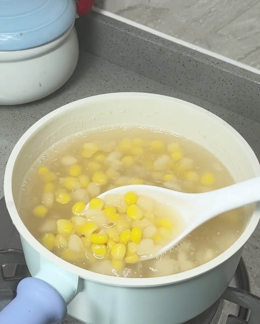 Lait de coco arrosé sur la casserole de soupe terminée au maïs et aux châtaignes deau.
