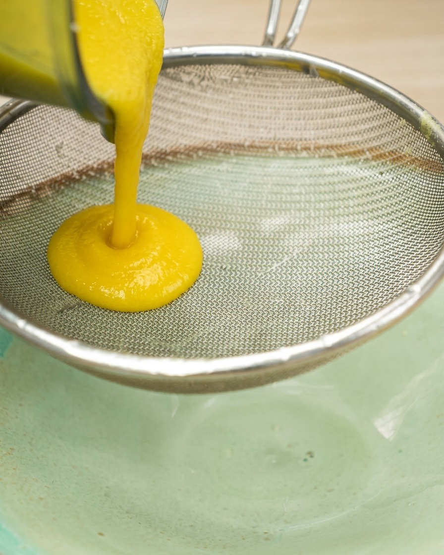 Purée de maïs épaisse passée au chinois au-dessus dun bol.