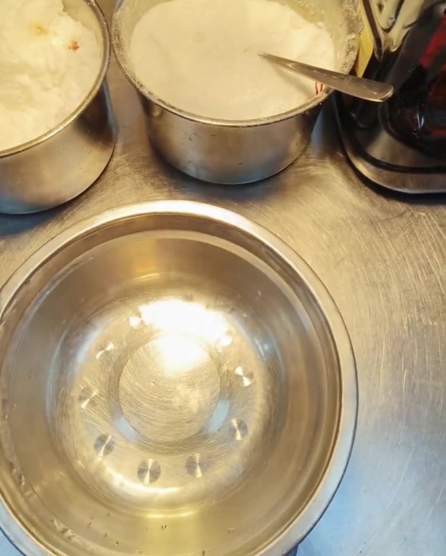 Plusieurs petits contenants en métal remplis de divers assaisonnements granulaires et liquides sur un plan de travail.