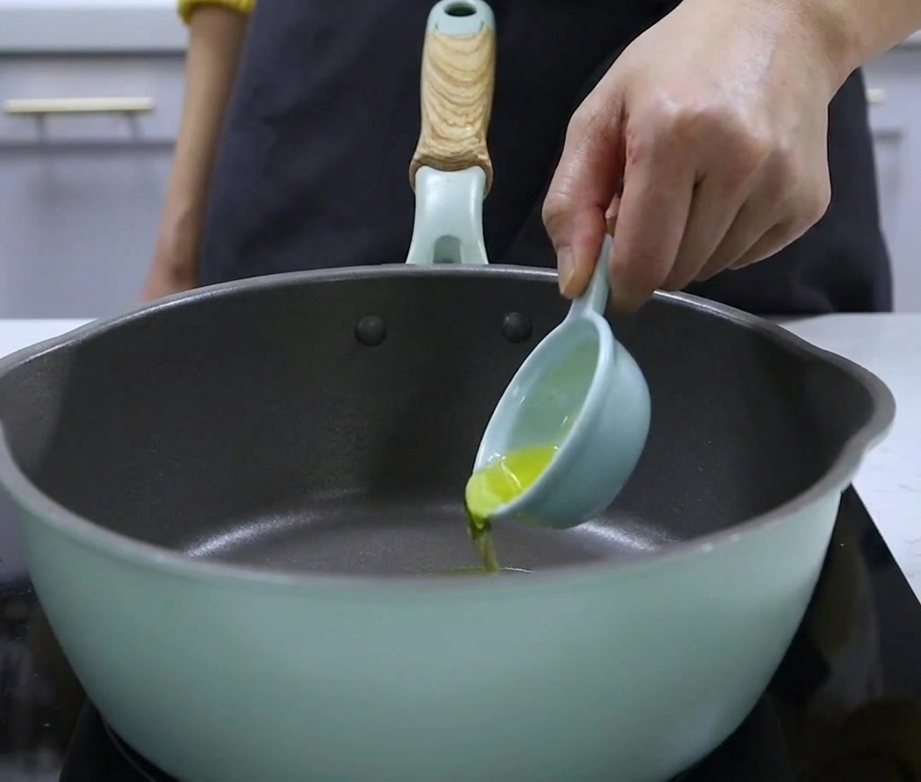 Verser de lhuile de noix avec une petite cuillère doseuse dans une casserole.