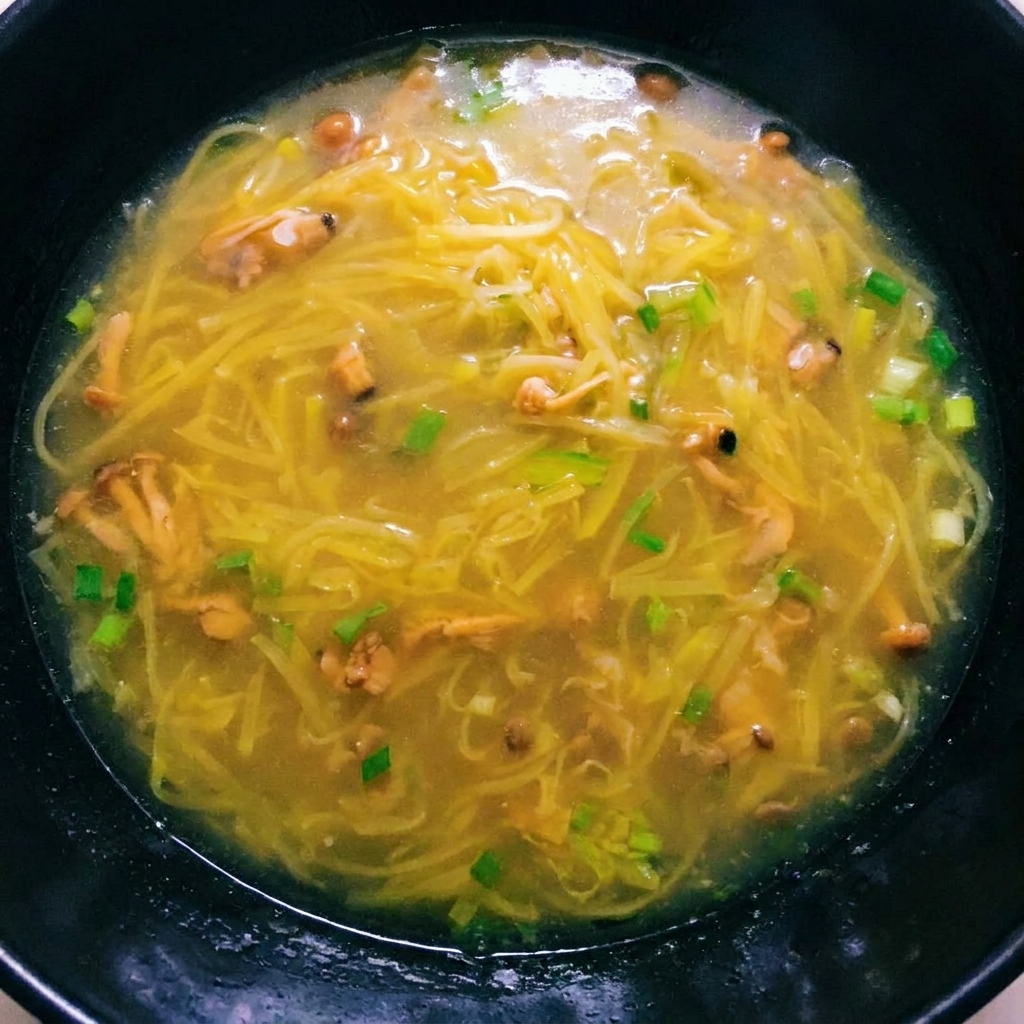 Une soupe de pommes de terre bouillante avec la chair de palourdes ajoutée, prête à être assaisonnée.