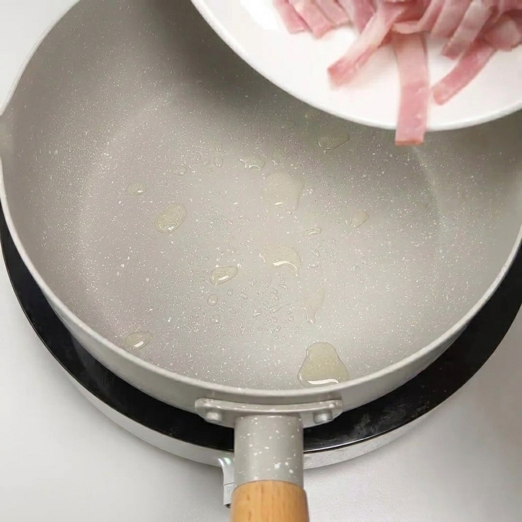 Des lanières de bacon cru ajoutées dans une poêle pour être grillées.