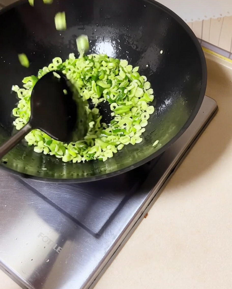 Haricots rouges hachés ajoutés dans le wok avec les oignons sautés.