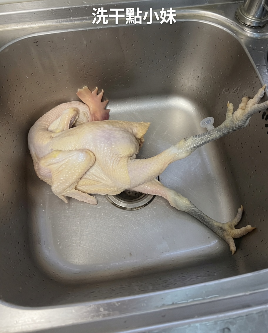 Un poulet entier cru étant rincé soigneusement dans un évier en acier inoxydable sous leau courante froide.