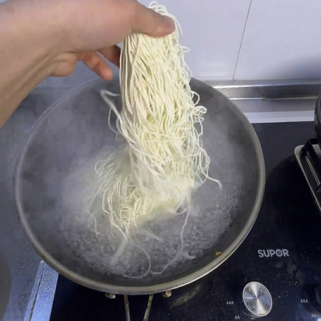 Des nouilles et du bok choy frais cuisant dans une casserole deau bouillante.