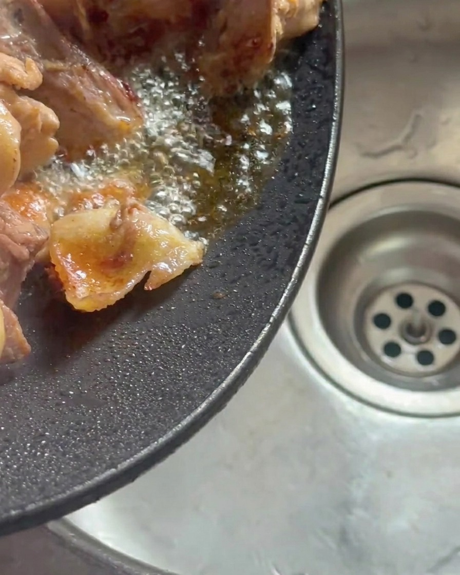 Wok incliné pour vider la graisse de poulet fondue.