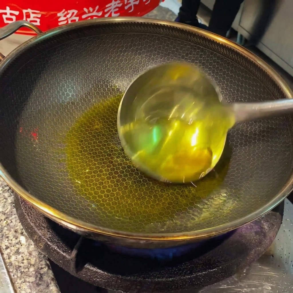 Tranches de gingembre et gousses dail grésillant dans lhuile chaude au wok.