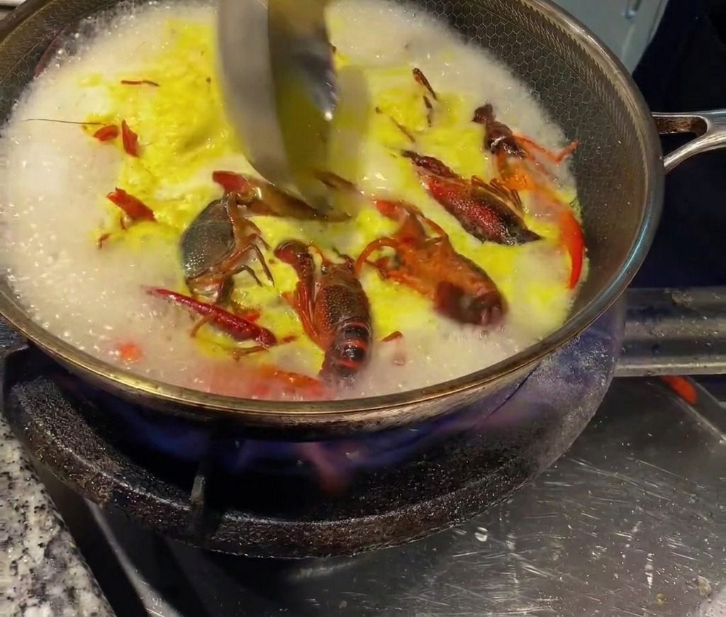 Une louche incorporant du bouillon de poulet concentré dans le bouillon chaud.
