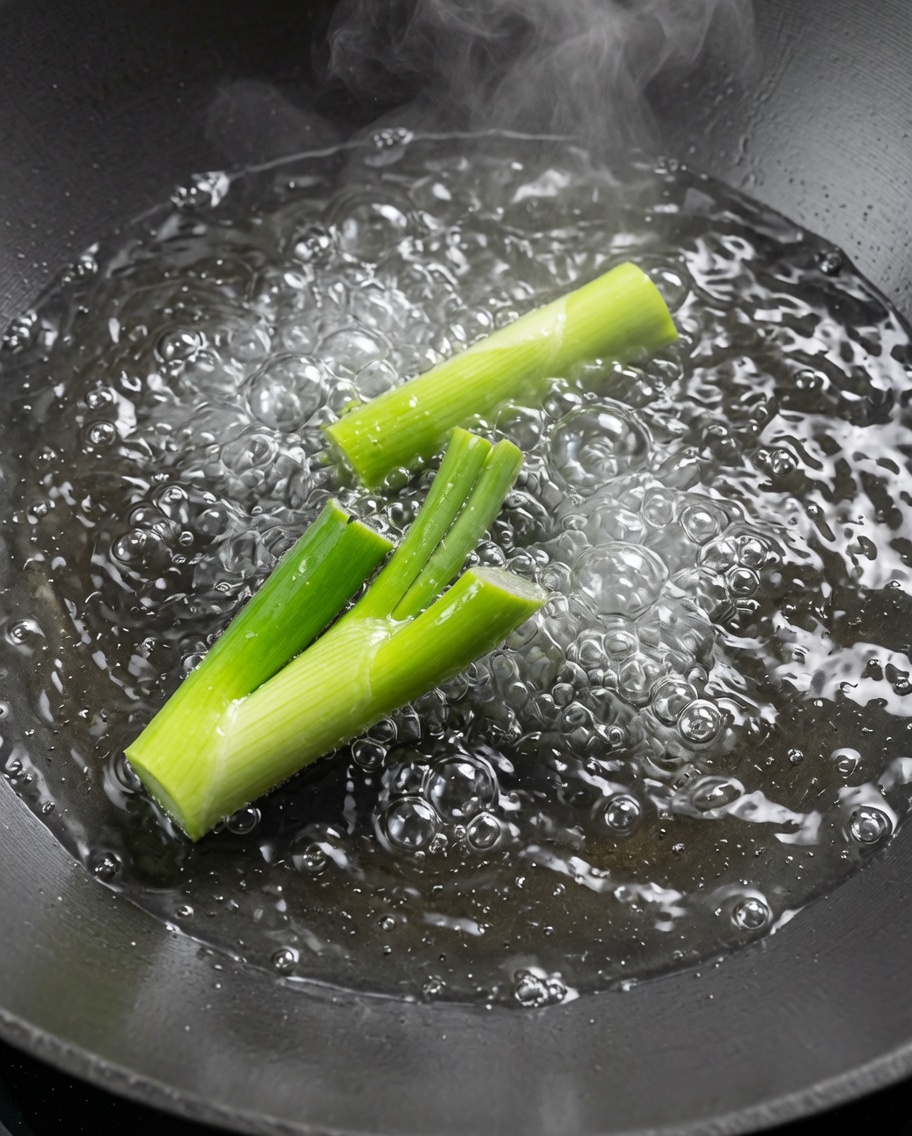 Écrevisses blanchies dans un grand wok deau bouillante avec des oignons verts.