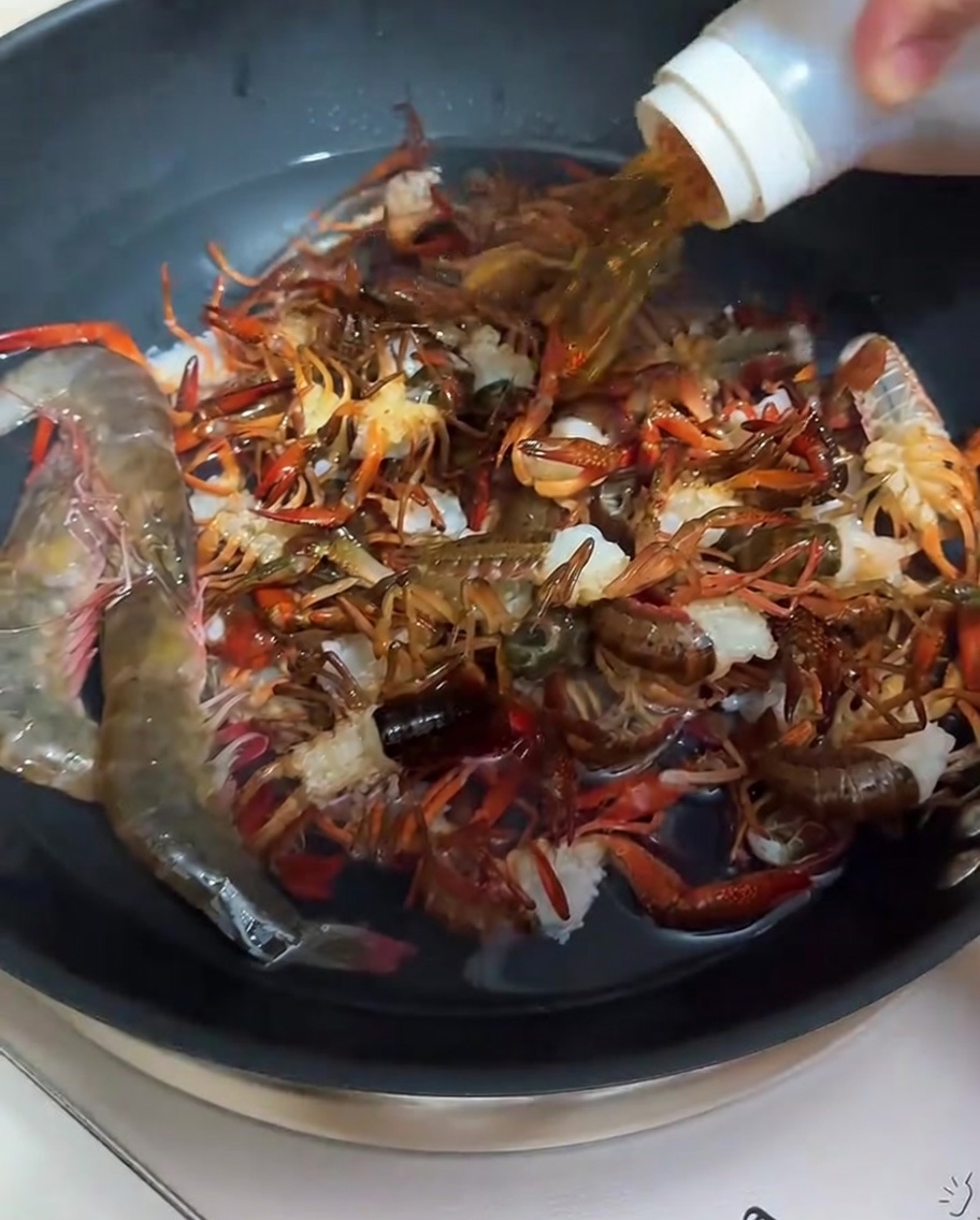 Écrevisses en cours de blanchiment dans une casserole avec de leau et du vin de cuisine.