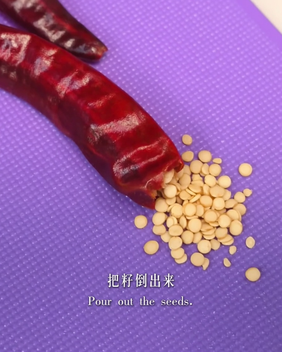 Un piment rouge séché ouvert pour en retirer les graines.
