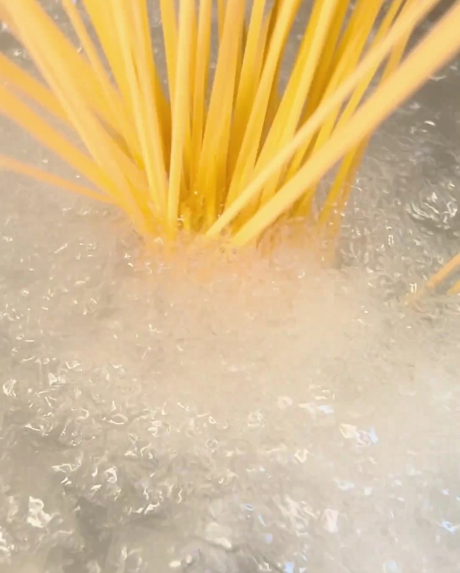 Des spaghettis plongés dans une casserole deau bouillante.