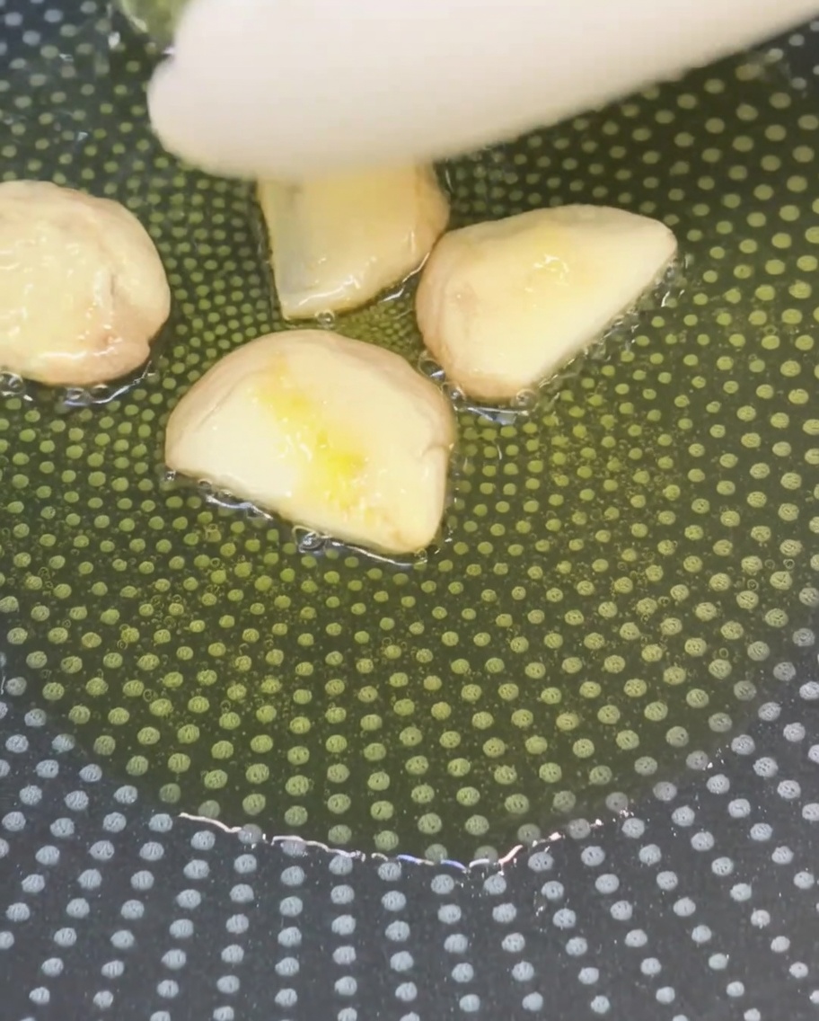 Gousses dail écrasées faisant frire doucement dans de lhuile dolive.