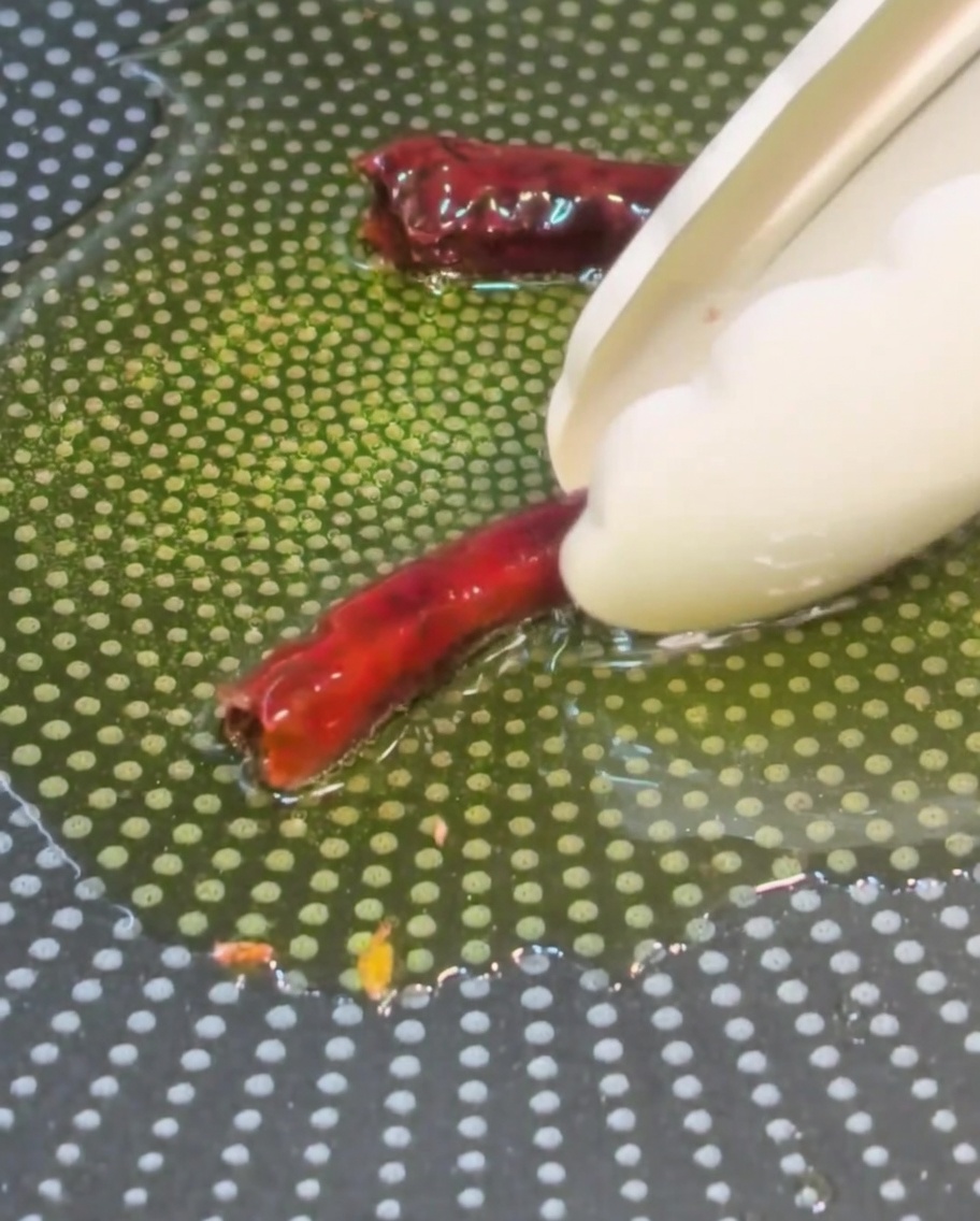 Piments ajoutés dans lhuile parfumée à lail.