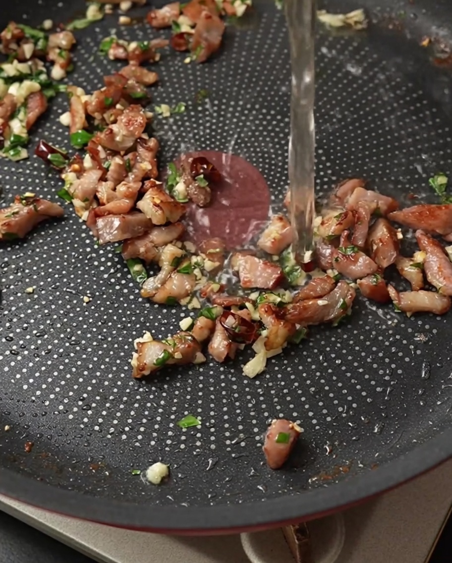 Verser du vin blanc dans une poêle contenant le bacon et les aromates.