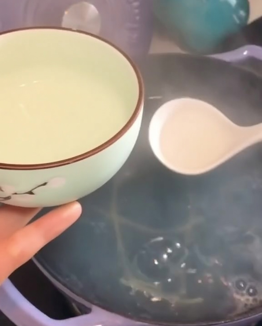 Louche remplissant un petit bol avec leau de cuisson trouble des pâtes.