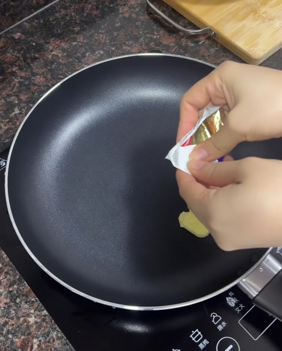 Beurre fondant dans une poêle noire antiadhésive chaude.