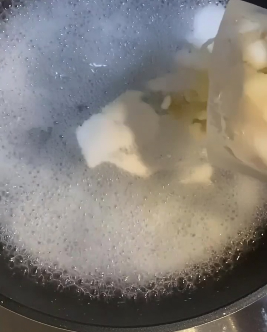 Crevettes crues ajoutées dans une casserole deau bouillante alors quelles commencent à cuire.