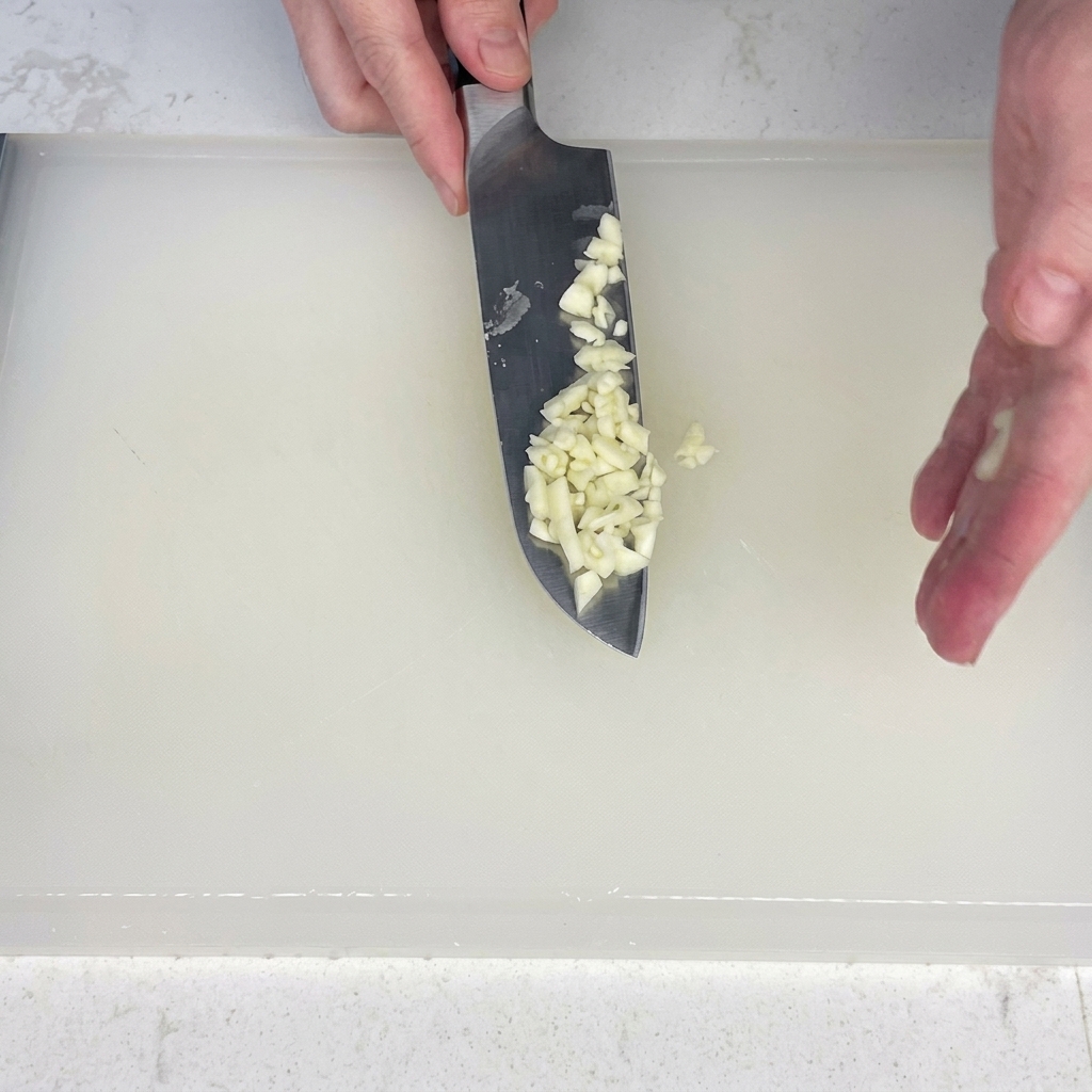 Tranches de lard coupées en petits morceaux sur une planche.